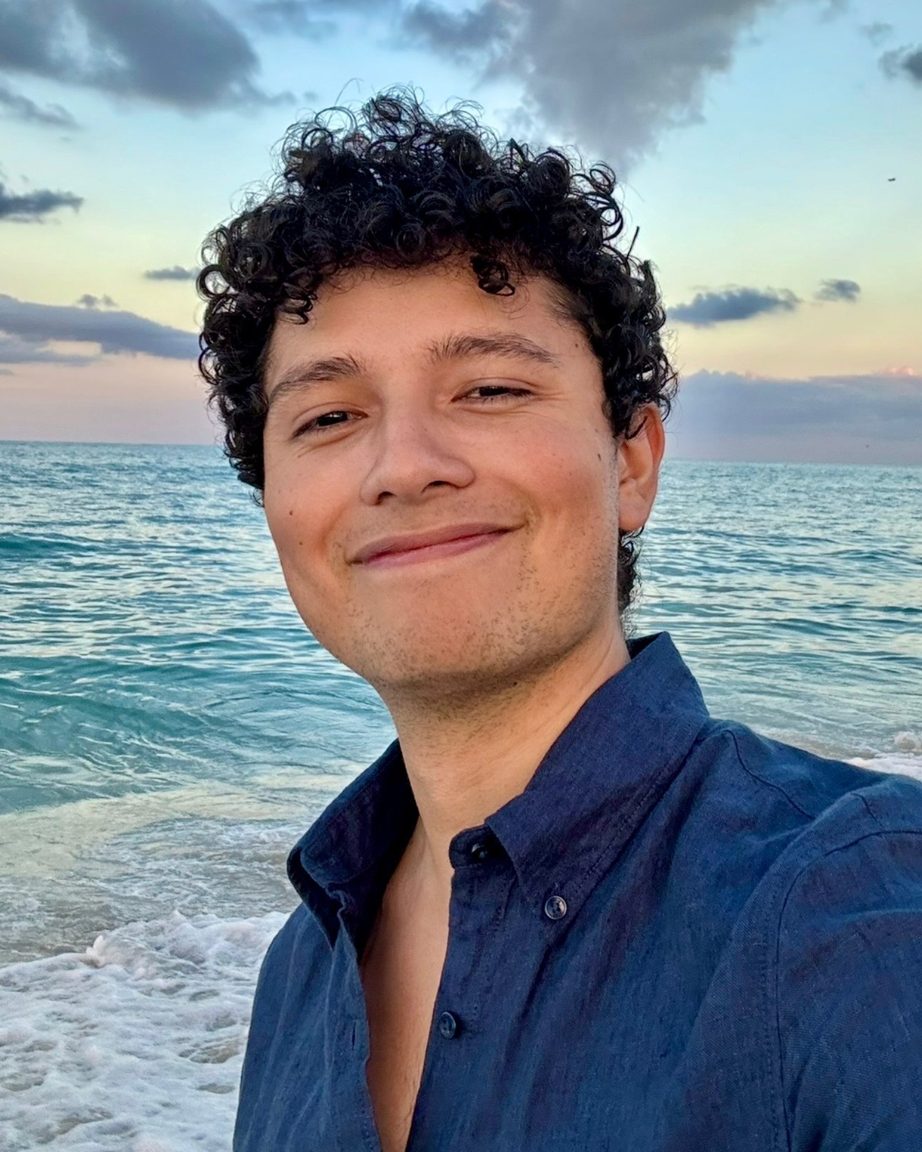 Smiling person taking a selfie at the beach.